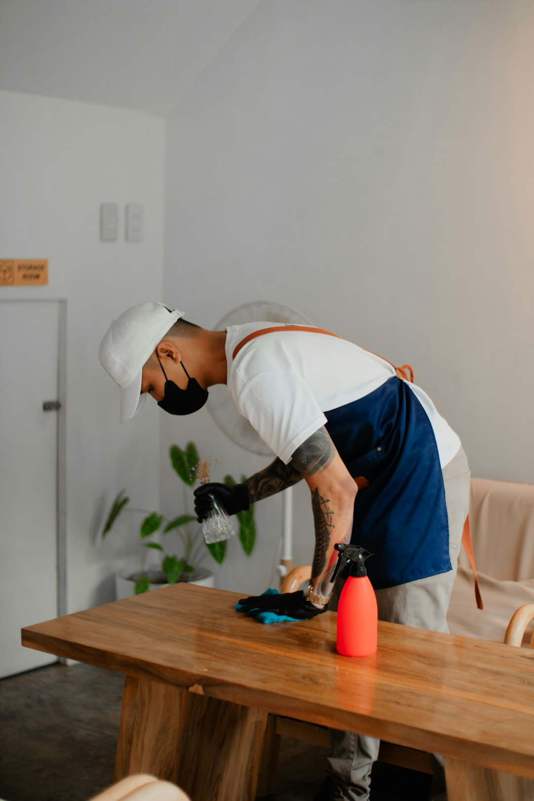 a-man-in-an-apron-is-sanding-a-wooden-table-qtpg6tfujp8